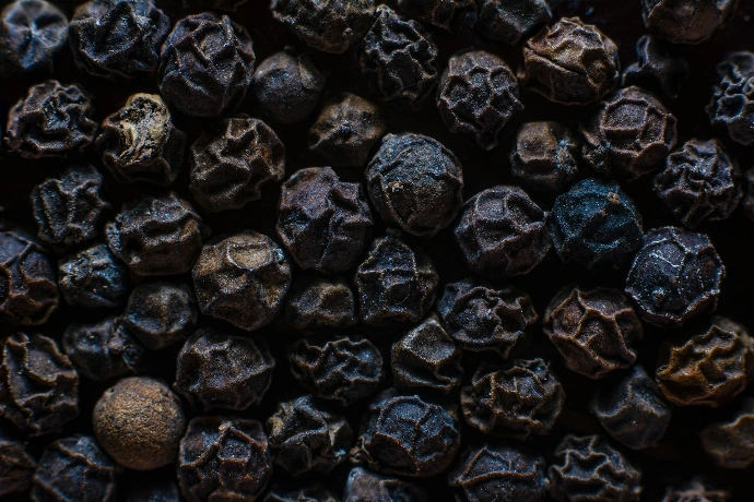 A close-up view of black peppercorns.